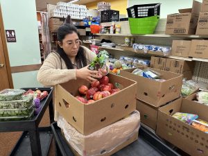Meeker Area Food Shelf assistant director Nancy Mendoza sorts produce received from Walmart before putting it into the food shelf's cooler.
